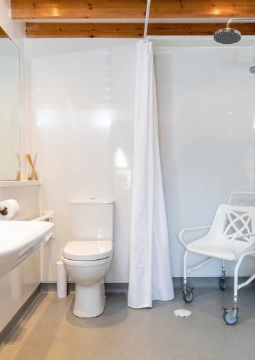 A wetroom with a movable chair.