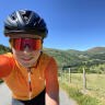 A man on a road bike cycling in a green valley.