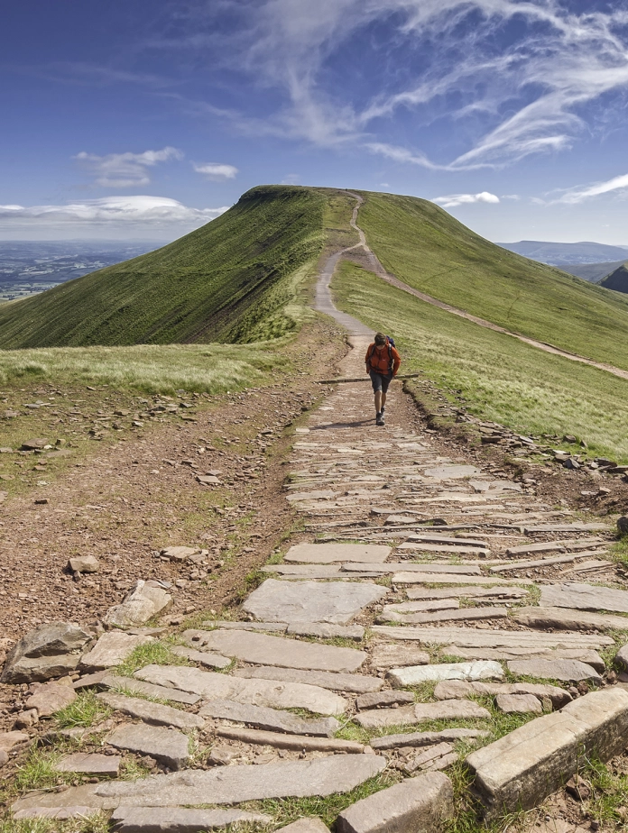 Cerddwr yn cerdded tuag at Pen Y Fan