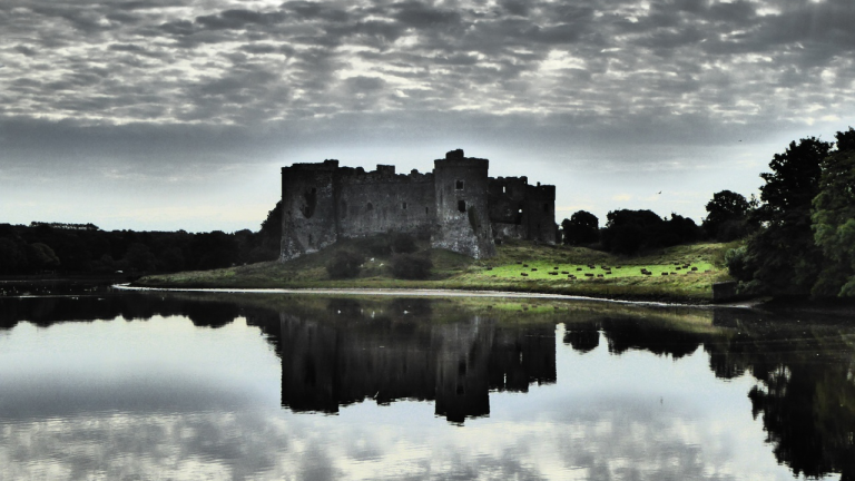 Golygfa o gastell Caeriw ger aber Cleddau gyda chymylau yn adlewyrchu yn  yr afon.