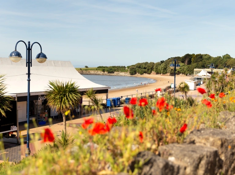 Golygfa o’r promenâd, y traeth a’r pentir yn y pellter. Ynys y Barri, De Cymru.