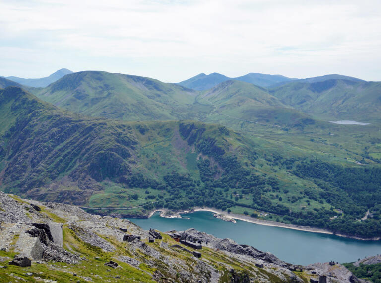 Llyn eang mewn cwm mynydd a welir o uchder.