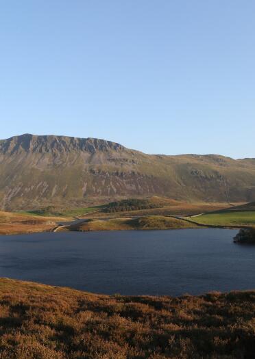 Llyn anghysbell ger mynyddoedd.