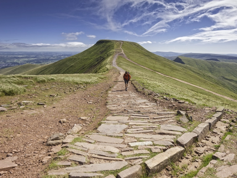 Cerddwr yn cerdded tuag at Pen Y Fan