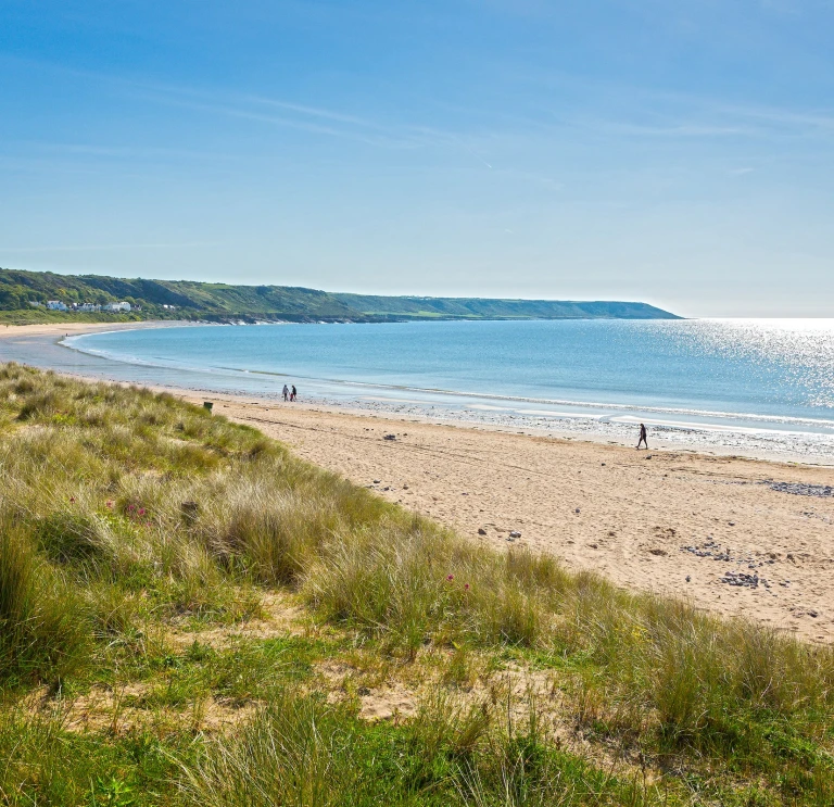 Traeth, gyda thwyni tywod yn y tu blaen, a'r môr yn y cefndir