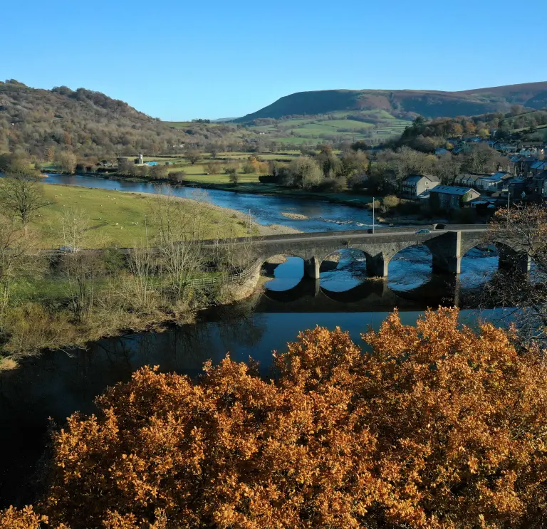 Golygfa o bont ac afon yn lliwiau’r hydref.