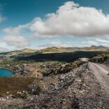 Quarry Kart yn Zip World yn erbyn cefndir o fynyddoedd a phwll glas.